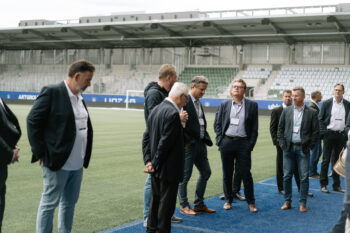 Menschen in Business Kleidung stehen auf dem Fußballfeld